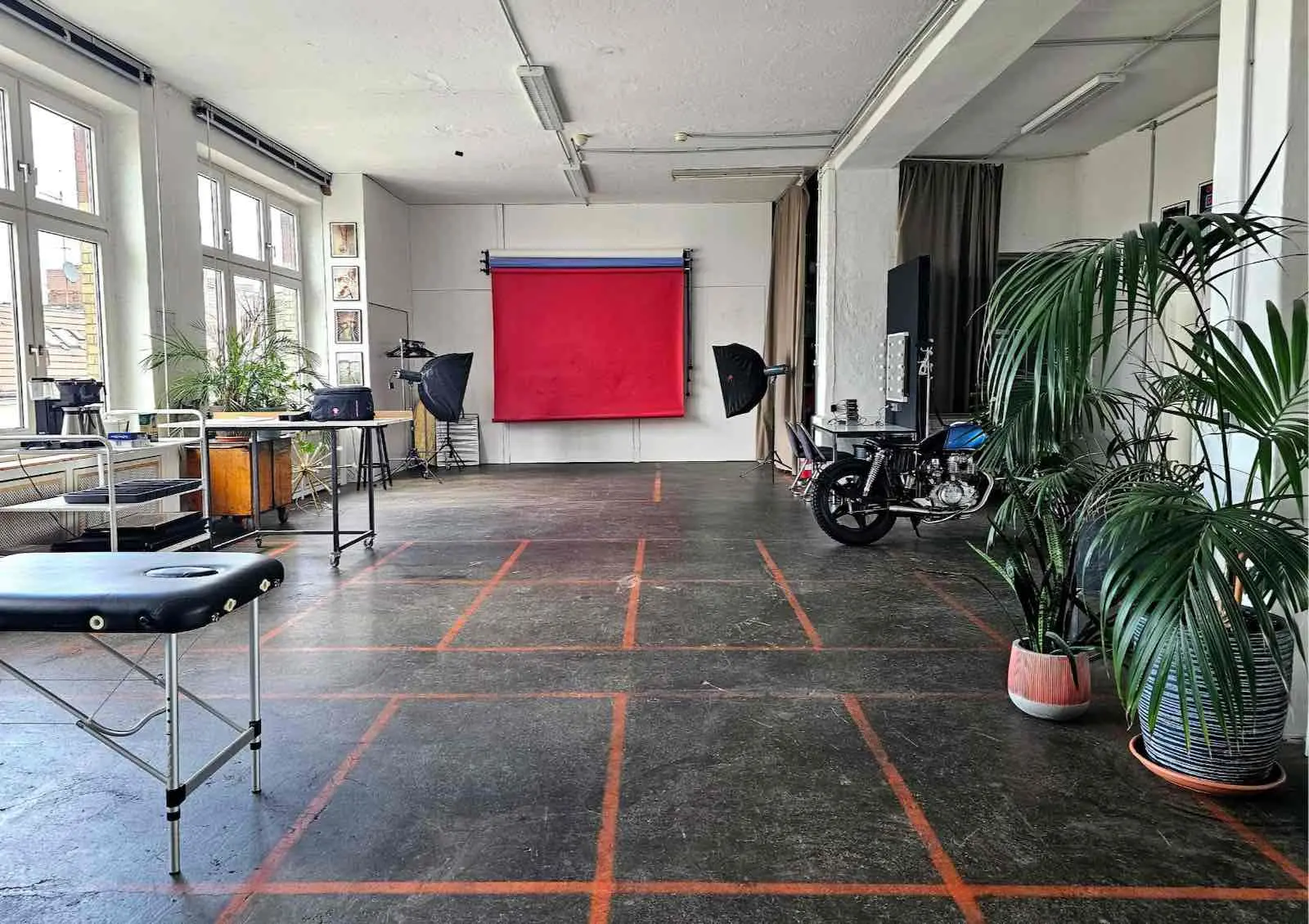 Großzügiges Mietstudio im ikonic STUDIO Berlin: Fotostudio mit rotem Hintergrund-System, Studio-Beleuchtung, Tageslicht und Loft-Charakter für Foto-Shootings und Video-Produktionen.