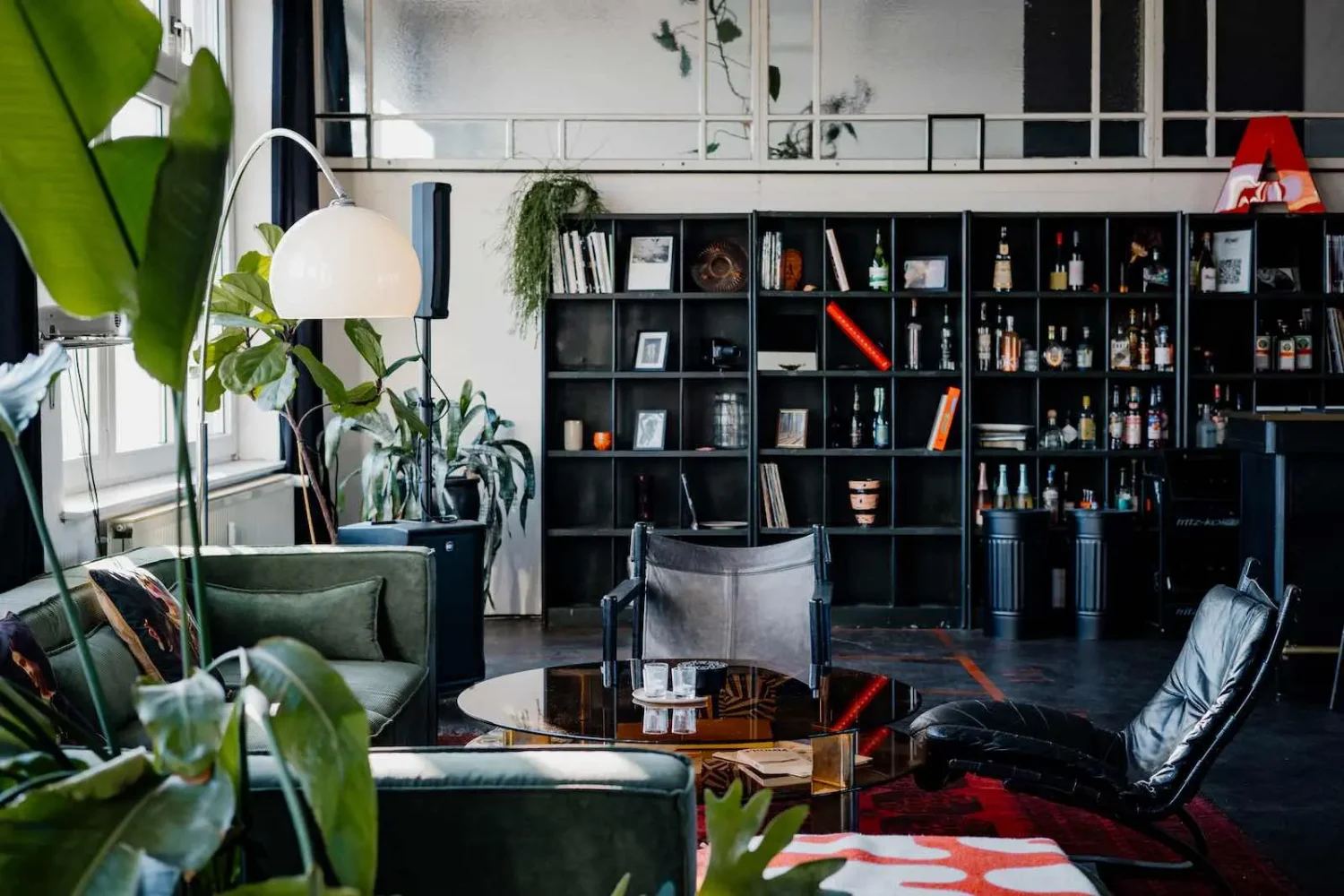 Exklusive Bar-Situation und Lounge-Bereich im ikonic STUDIO Berlin: Hochwertiges Interior mit Design-Sesseln und Bar-Regal für Events und Partys.